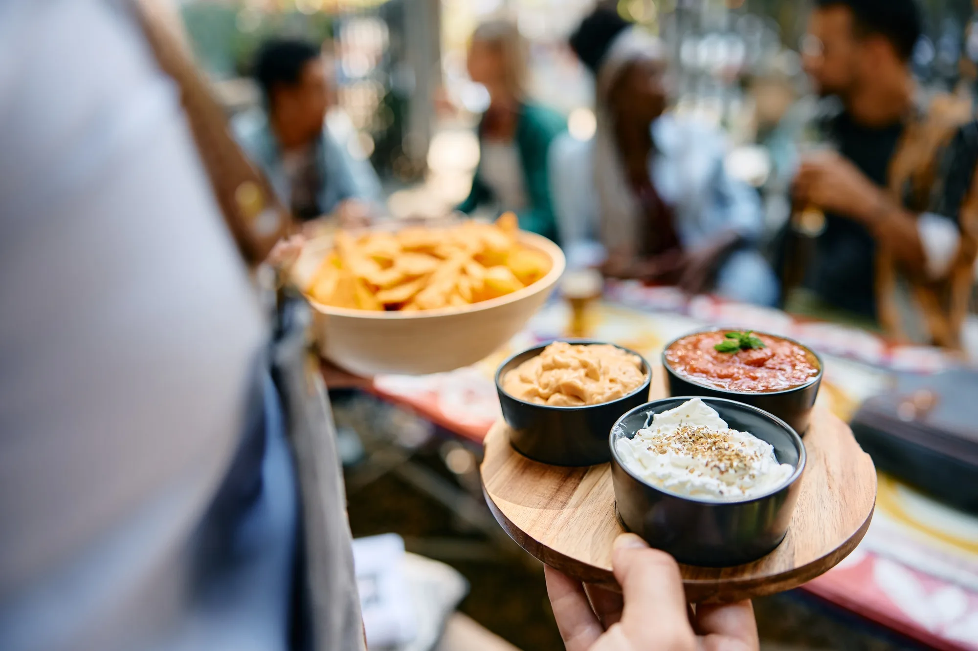 Close up of waiter serving food while working in a restaurant.